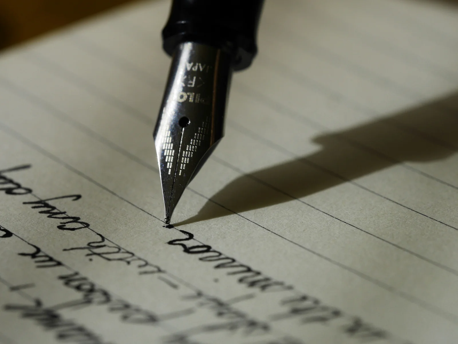 A fountain pen resting on a handwritten page